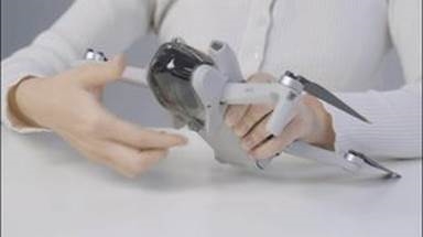 dji - Mini 3 - Retirar la cubierta de almacenamiento Retirar la cubierta de almacenamiento