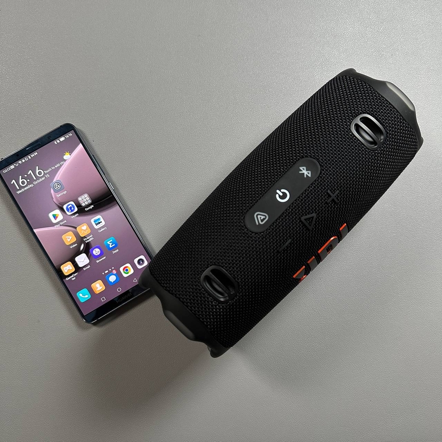 Altavoz JBL Charge 6 junto a un teléfono Android